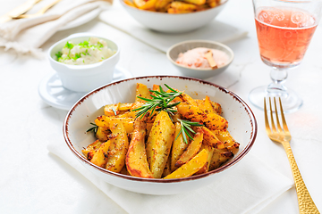 Image showing Homemade baked potato wedges with garlic dip