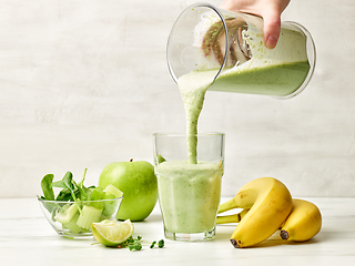 Image showing fresh green smoothie pouring into glass