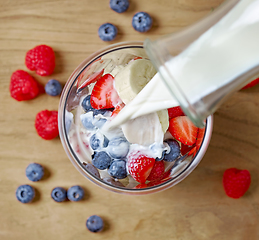 Image showing milk pouring into glass of fruit