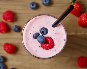 Image showing glass of fresh banana and berry milkshake