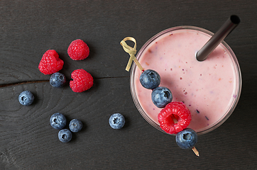 Image showing glass of fresh banana and berry milkshake