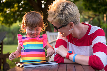 Image showing mom and her little daughter using tablet computer