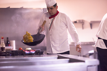 Image showing chef flipping vegetables in wok