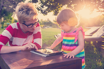 Image showing mom and her little daughter using tablet computer