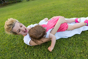 Image showing mother and little daughter playing at backyard