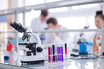 Image showing Microscope on the workplace near test tubes