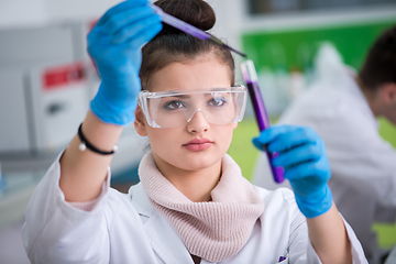 Image showing female student with protective glasses making chemistry experime