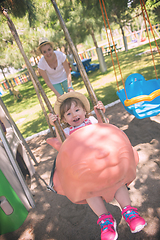 Image showing mother and daughter swinging in the park