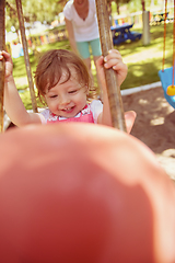 Image showing mother and daughter swinging in the park