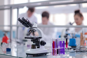 Image showing Microscope on the workplace near test tubes