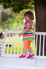 Image showing cute little girl sitting on wooden bench