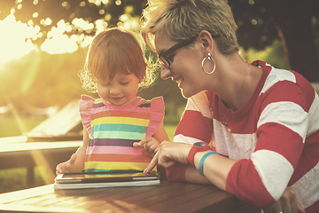 Image showing mom and her little daughter using tablet computer