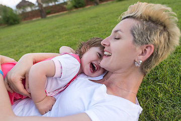 Image showing mother and little daughter playing at backyard