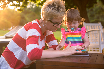 Image showing mom and her little daughter using tablet computer