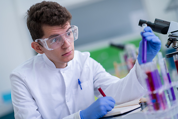 Image showing student with protective glasses making chemistry experiment