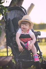 Image showing baby girl sitting in the baby stroller