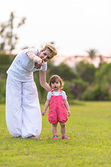 Image showing mother and little daughter playing at backyard