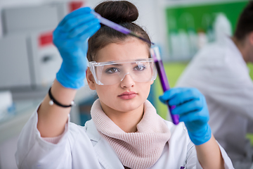 Image showing female student with protective glasses making chemistry experime