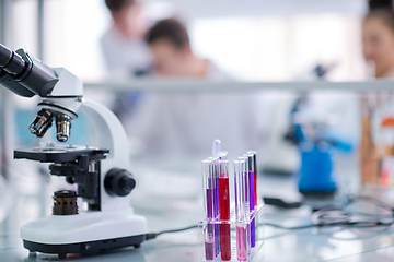 Image showing Microscope on the workplace near test tubes