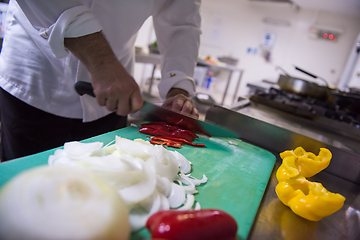 Image showing Chef hands cutting fresh and delicious vegetables