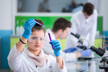 Image showing female student with protective glasses making chemistry experime