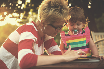 Image showing mom and her little daughter using tablet computer