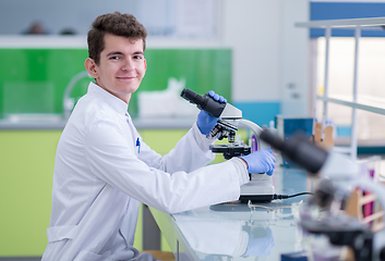 Image showing student scientist looking through a microscope