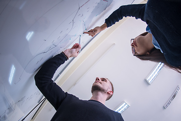 Image showing students writing on the white chalkboard