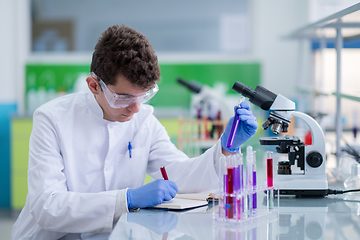 Image showing student with protective glasses making chemistry experiment