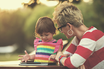 Image showing mom and her little daughter using tablet computer