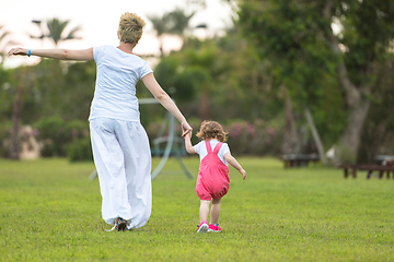 Image showing mother and little daughter playing at backyard