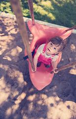 Image showing little girl swinging  on a playground