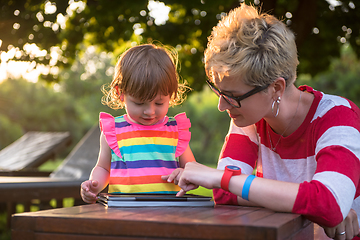 Image showing mom and her little daughter using tablet computer