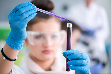 Image showing female student with protective glasses making chemistry experime