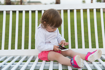 Image showing little girl playing with mobile phone