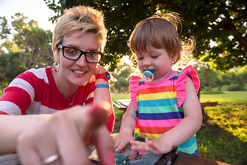 Image showing mom and her little daughter using tablet computer