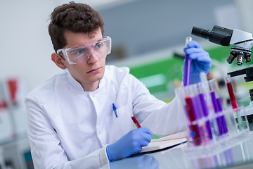 Image showing student with protective glasses making chemistry experiment