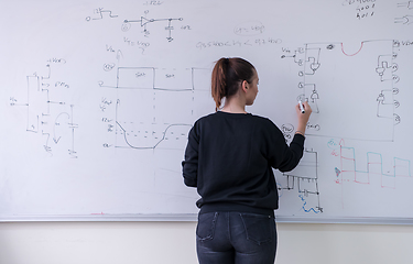 Image showing female student writing on board in classroom