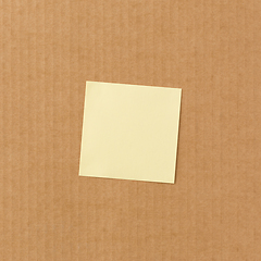 Image showing Yellow sticky paper note on cardboard