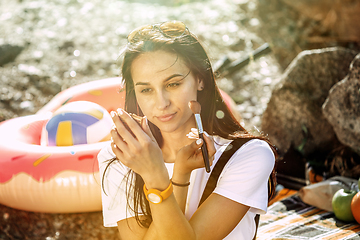 Image showing Young couple having picnic at riverside in sunny day