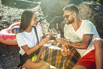 Image showing Young couple having picnic at riverside in sunny day