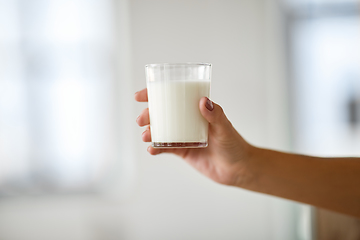 Image showing close up of female hand holding glass of milk