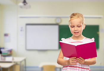 Image showing smiling little girl reading book