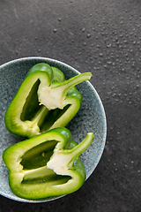 Image showing cut green pepper in bowl on slate stone background