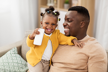 Image showing father and baby daugter with smartphone at home