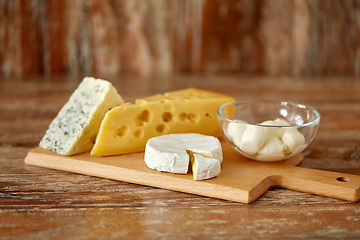 Image showing different kinds of cheese on wooden cutting board