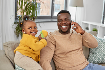 Image showing father with baby at home calling on smartphone