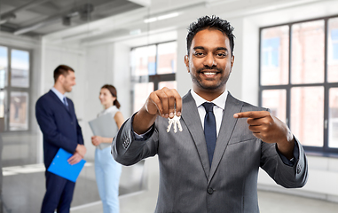 Image showing indian man realtor with keys at empty office room