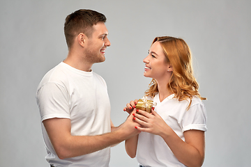 Image showing happy couple in white t-shirts with christmas gift