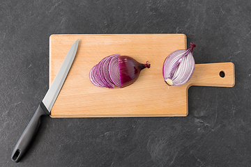 Image showing red onion and kitchen knife on cutting board